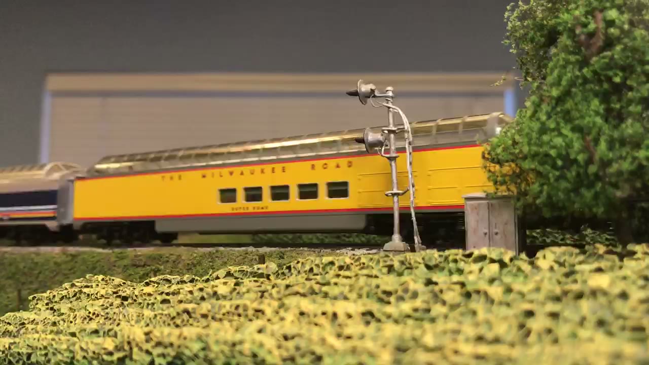 Train crossing a stone arch bridge through the hills
