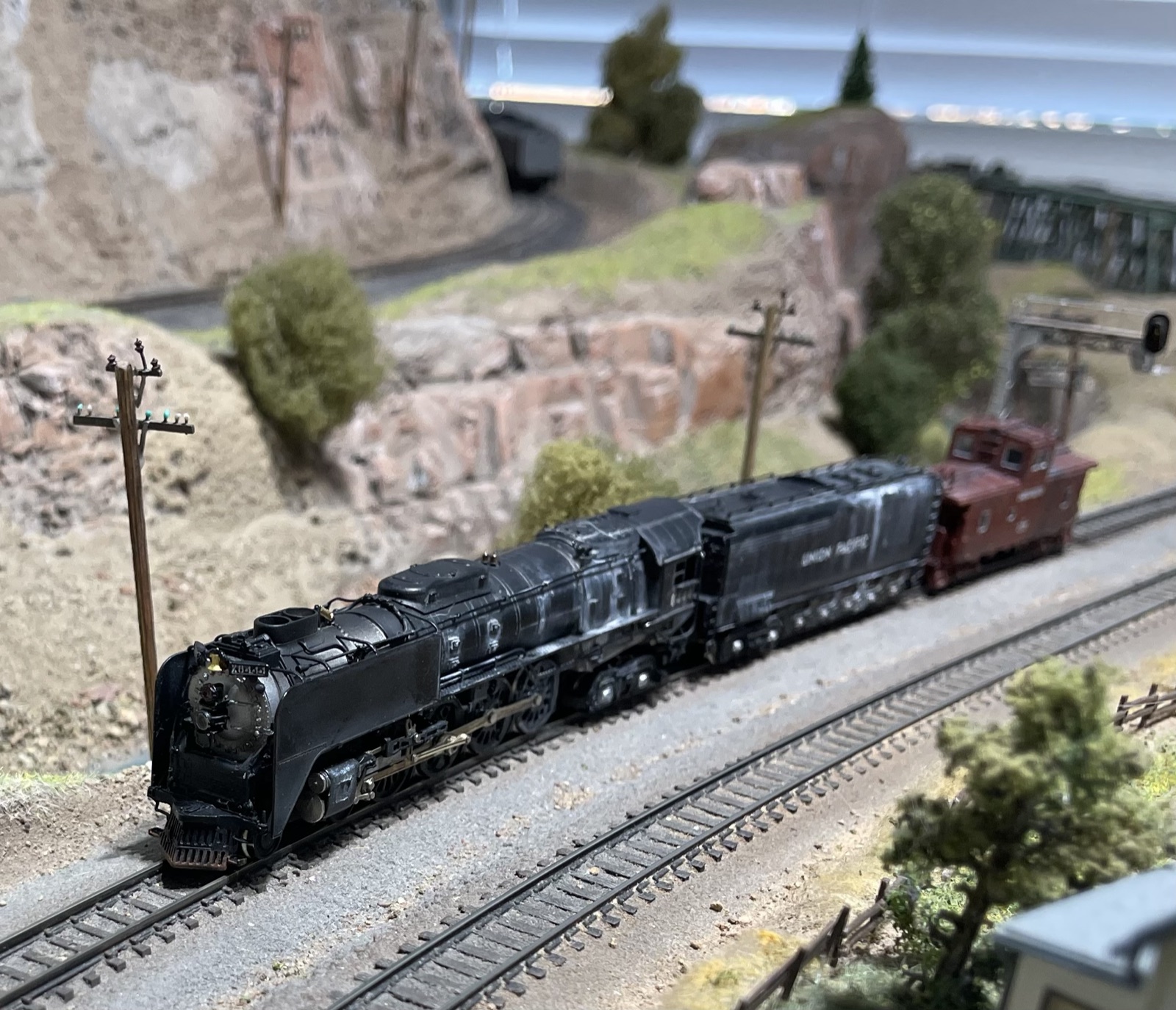 Steam locomotive hauling a long train past the mountains